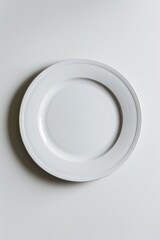 Poster - A simple white plate placed on a table, ideal for food photography or still life scenes