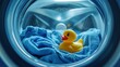 © fotofabrika - A playful rubber duck rests on soft blue fabric inside a washing machine during a bright laundry day