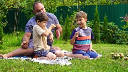 Wall Mural - Father and sons have picnic on the backyard, have fun and time together