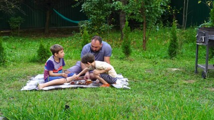 Wall Mural - Father and sons have picnic on the backyard, have fun and time together