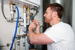© erikrous - Technician adjusting a valve on a pipe from a heat pump