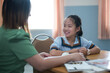 © EduLife Photos - Young student in a school uniform smiling during a tutoring session.