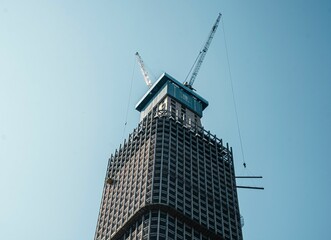 Wall Mural - High-rise building under construction with cranes.