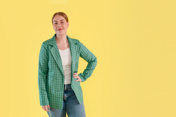 Stylish Young Woman Posing With Confidence Against Cheerful Yellow Backdrop During Daylight