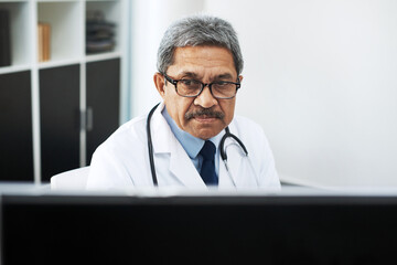 Canvas Print - Computer, face and healthcare with mature doctor in hospital office for administration or planning. Cardiology, medical and research with medicine professional in clinic for diagnosis or information