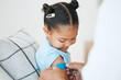 © KayExam/peopleimages.com - Little girl, doctor and vaccine with plaster for protection, health and safety from virus in bed at home. Child, kid and medical employeee with bandaid for vaccination, cure or healthcare at house