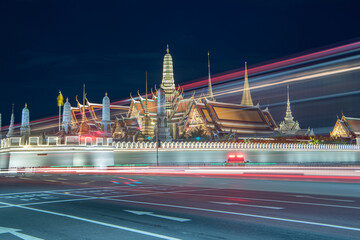 Emerald Buddha Temple or Wat Phra Kaew, Grand Palace, a Buddhist temple at night with cars lights in Bangkok, Thailand.