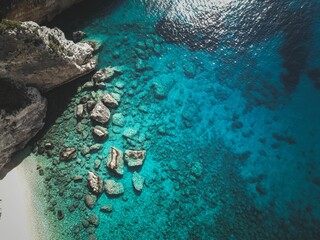 Aerial view of rocky cliffs and turquoise waters on a sunny day on Zakynthos Island in Greece