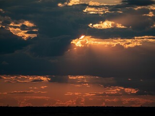 dramatic sunset with dark clouds and vibrant orange hues illuminating the sky
