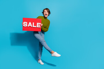 Full length photo of funky positive girl wear trendy outfit clothes show banner sale empty space isolated on cyan color background