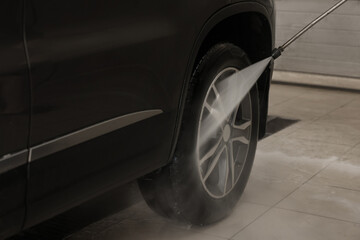 Wall Mural - Washing auto with high pressure water jet at car wash, closeup