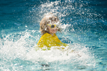 Wall Mural - Kid enjoying summer holiday, swiming in pool. Kid having fun on summer holidays at pool. Happy kids playing on pool water. Happy Summer. Child on summer vacations play in the water.