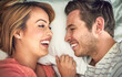 © AK Coop/peopleimages.com - Love, romantic and happy couple laughing in bed for house rental, bonding and marriage with joke. Funny, relax or man with woman on break, honeymoon or staycation for anniversary retreat and wake up