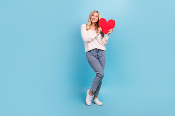 Wall Mural - Photo of lovely pretty woman wear trendy white clothes hold heart sign look empty space isolated on blue color background