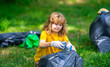 © Volodymyr - Kid helps to pick up garbage. Pollute forest. Rubbish trash. Planet pollution environmental protection concept. Cleaning up the forest. Child putting trash in garbage bags, environmental protection.