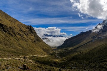 Wall Mural - Stunning view of the snow-capped Salkantay Mountain peak with clouds against a clear blue sky.