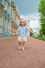 Wall Mural - Little girl child walks to Catherine's Park with a palace, family tourism, active childhood.