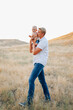 © Chelsea - Father and baby boy, walking in a field.