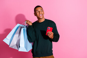 Sticker - Photo of handsome dreamy guy wear sweatshirt holding shoppers ordering modern gadget emtpy space isolated pink color background