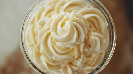 A jar of whipped cream with a swirl of white frosting on top