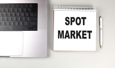 Poster - Spot market concept with notepad, laptop, and pen on a gray desk