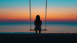 © Jirut - Back view of a single woman alone, gently swinging on a beach swing