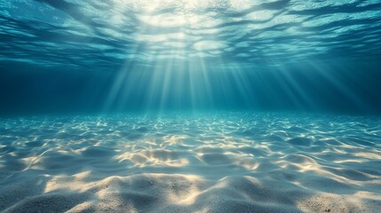 Underwater background deep blue sea and beautiful light rays with sandy floor.