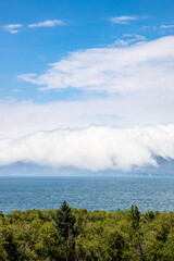 Wall Mural - arge white cloud over shore of Lake Sevan, Armenia