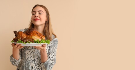 Poster - Beautiful young woman holding tasty baked turkey on beige background with space for text. Thanksgiving Day celebration