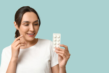 Sticker - Pretty young woman with pills on blue background