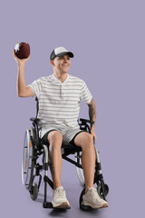 Wall Mural - Sporty young man in wheelchair with rugby ball on lilac background