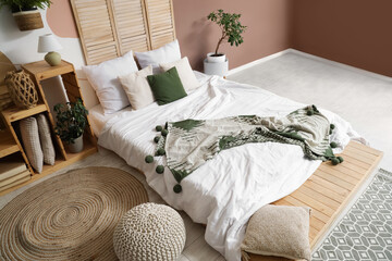 Wall Mural - Stylish interior of bedroom with bed, pillows and houseplant