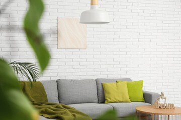 Sticker - Hanging lamp, soft sofa with plaid,  picture and coffee table near white brick wall in room