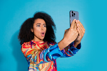 Canvas Print - Photo portrait of pretty young girl hold gadget shocked wear trendy colorful outfit isolated on blue color background