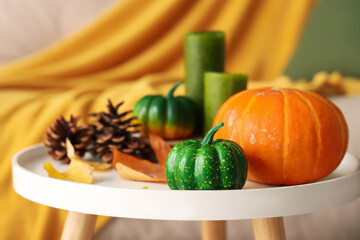 Wall Mural - Pumpkins, candles, cones and autumn leaves on coffee table in living room. Closeup