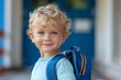 © Andrei - Little blond boy with a backpack. He smiles and is happy to return to school