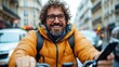 © LifeMedia - A cheerful man wearing an orange jacket rides a bicycle through a city street, illustrating the joy of urban cycling and the vibrancy of city life.