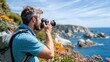 © LifeMedia - A man with a backpack photographing a picturesque coastal landscape with rocky shores, flowers, and clear blue skies, capturing the beauty of nature in a serene moment.