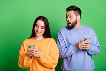 Wall Mural - Photo of cheerful girl writing sms reading social media post news isolated on green color background