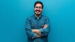 © The Little Hut - Young hispanic man wearing blue shirt and glasses looking at camera with positive confident smile holding arms crossed isolated on blue background : Generative AI