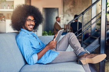 Poster - Happy man, portrait and afro with tablet on sofa for online browsing, research or creative design at office. Young, male person or designer with smile on technology for network, connectivity or app