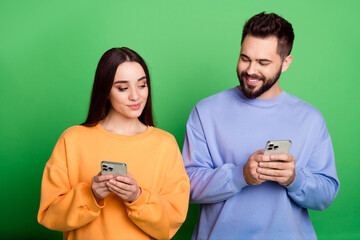 Sticker - Photo of lovely pretty couple wear stylish outfit hold use modern device isolated on green color background