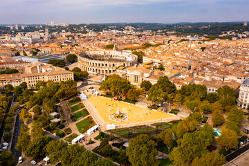 Aerial view of historical area of French city of Nimes overlooking restored antique Roman amphitheatre on sunny autumn day