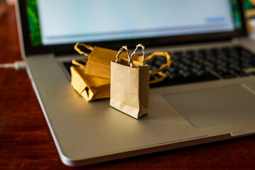 Paper shopping bags on laptop in office . Ideas about online shopping addiction.