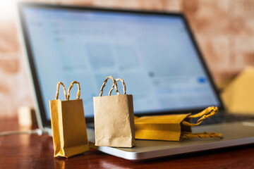 Paper shopping bags on laptop in office . Ideas about online shopping addiction.