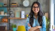 © Christopher - Cheerful Indian girl standing in a home office, business theme with a plain office background