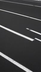 Poster - A black and white image of a road with white lane markings.
