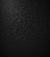 a dark, textured surface with a pattern of small, irregularly shaped black dots or squares. The background is completely black, creating a stark contrast with the dark