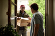 © mavoimages - Man signing for a courier package at his front door
