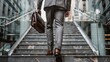 © Usman - Businessman in grey suit and brown leather shoes carrying black briefcase on steps of modern building